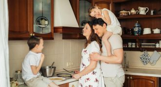 A joyful family moment as parents and children cook together in a cozy kitchen setting.