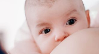 baby lying on white bed